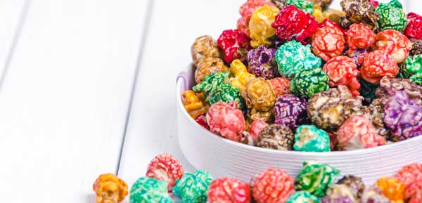 bright colorful pieces of popcorn sitting in a white bowl